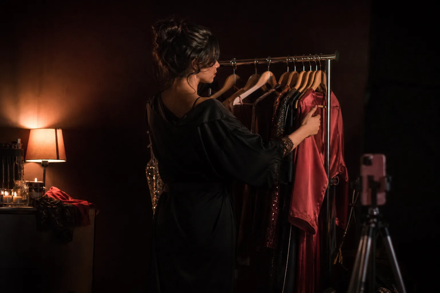 Creator arranging outfits on a clothing rail before a shoot
