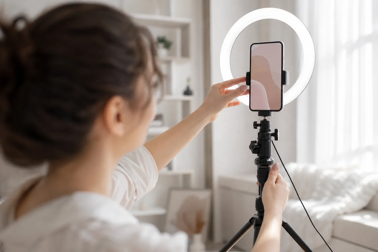Smartphone on a tripod with a ring light being adjusted before a shoot
